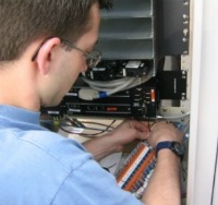 Purcell Systems field service expert installs an upgrade to an outdoor equipment enclosure
